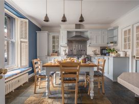 A kitchen with a dining table and chairs at Westhill House in Warkworth