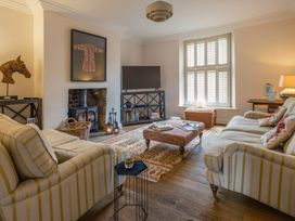 A living room with a television, fireplace, and coffee table at Westhill House Warkworth