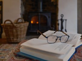 A book and glasses on a table with a fireplace at Westhill House Warkworth