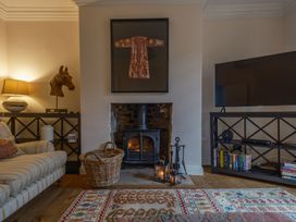 A living room with a fireplace and television at Westhill House Warkworth