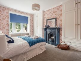 A bedroom with a bed and a fireplace at Westhill House in Warkworth