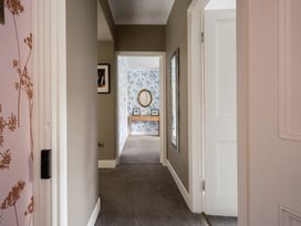 A hallway with a mirror and table at Westhill House Warkworth