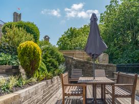 A garden with a table and chairs at Westhill House Warkworth