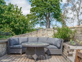 An outdoor seating area with a sofa and table at Westhill House in Warkworth