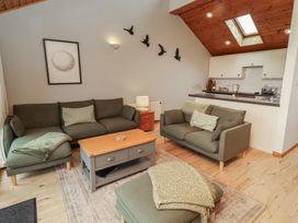 A living room with seating and kitchen counter at Links View in Embleton