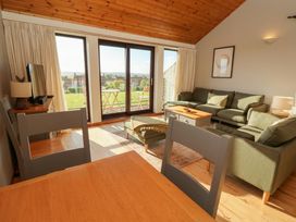 A living room with a sofa and dining table at Links View in Embleton