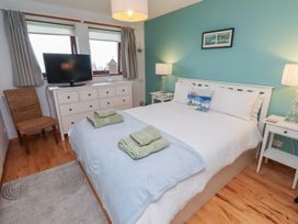 A bedroom with a bed and a television at Links View in Embleton