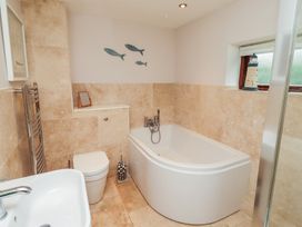A bathroom with a bathtub, toilet, and sink at Links View in Embleton