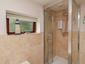 A bathroom with a shower and lighthouse decor at Links View in Embleton