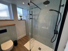 A shower and toilet in a bathroom at Sea Croft in Beadnell