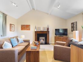 A living room with a sofa, coffee table, and television at Plumtree Cottage in Alnmouth