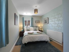 A bedroom with a bed and bedside table at Plumtree Cottage in Alnmouth