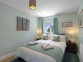 A bedroom with a bed and bedside table at Plumtree Cottage in Alnmouth