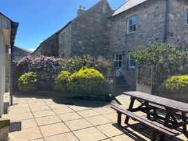An outdoor area with benches and flowering shrubs at Beachward in Embleton