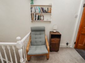 A hallway with a chair and bookshelf at Hardys House in Alnwick