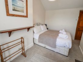 A bedroom with a bed and shelves at Hardys House Alnwick