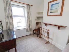 A bedroom with a window, chair, table, and shelf at Hardys House in Alnwick