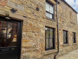 An exterior wall of a stone house with windows and a door at Lavender Cottage (Bailiffgate) Alnwick
