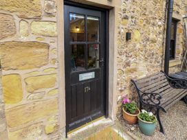 An entrance door with a nameplate and a bench at Lavender Cottage in Alnwick