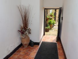 A hallway with a flower arrangement and a view of the garden at Lavender Cottage (Bailiffgate) Alnwick