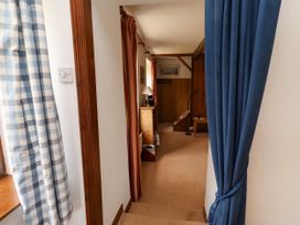 A hallway with stairs and a wooden cabinet at Lavender Cottage (Bailiffgate) Alnwick