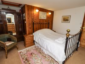 A bedroom with a bed and wardrobe at Lavender Cottage (Bailiffgate) Alnwick