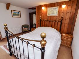 A bedroom with a bed and nightstand at Lavender Cottage (Bailiffgate) Alnwick