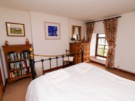 A bedroom with a bed and bookshelf at Lavender Cottage (Bailiffgate) Alnwick