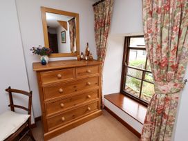A bedroom with a chest of drawers and a window at Lavender Cottage (Bailiffgate) Alnwick