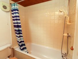 A bathroom with a bathtub and shower at Lavender Cottage (Bailiffgate) Alnwick