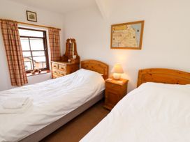 A bedroom with two beds and a window at Lavender Cottage (Bailiffgate) Alnwick