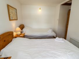 A bedroom with two beds and a map on the wall at Lavender Cottage (Bailiffgate) Alnwick