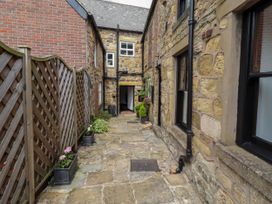 An outdoor corridor with stone walls and planters at Lavender Cottage (Bailiffgate) Alnwick
