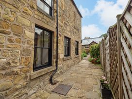 An outdoor space with stone walls, pathway, and plants at Lavender Cottage (Bailiffgate) Alnwick