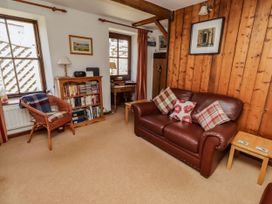 A living room with a sofa and bookshelf at Lavender Cottage (Bailiffgate) in Alnwick