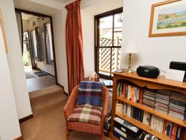 A hallway with a chair and bookshelf at Lavender Cottage (Bailiffgate) Alnwick