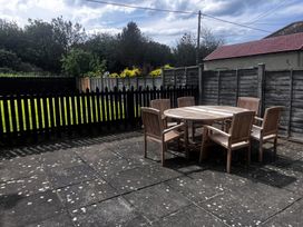 A garden with a wooden table and chairs at Glenavon in Seahouses