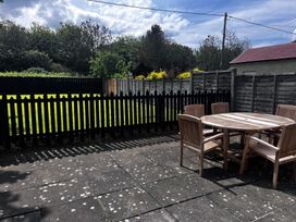 A garden with a wooden table and chairs at Glenavon in Seahouses