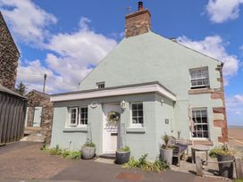 A house with a door and windows at Marie's Cottage in Craster