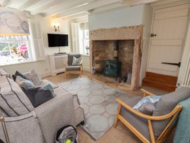 A living room with a sofa and television at Marie's Cottage in Craster