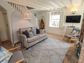 A living room with a sofa and television at Marie's Cottage, Craster