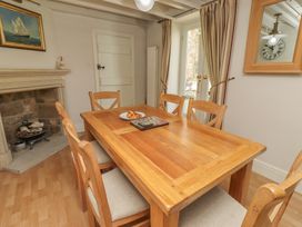A dining room with a wooden table and chairs at Marie's Cottage in Craster