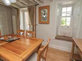 A dining room with a table and chairs at Marie's Cottage in Craster