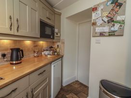 A kitchen with a kettle, microwave, and fridge at Marie's Cottage in Craster