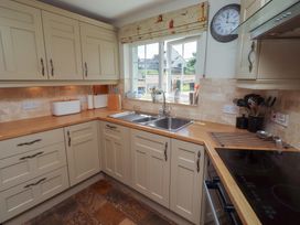 A kitchen with cabinets and sink at Marie's Cottage in Craster