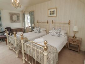 A bedroom with two single beds and a mirror at Marie's Cottage in Craster
