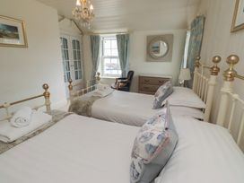 A bedroom with twin beds and a dresser at Marie's Cottage in Craster