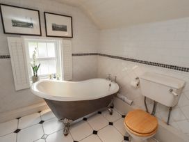 A bathroom with a bathtub and toilet at Marie's Cottage in Craster