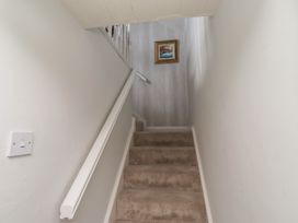 Stairs with handrail and painting at Marie's Cottage in Craster