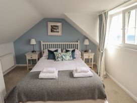 A bedroom with a bed and bedside tables at Marie's Cottage in Craster